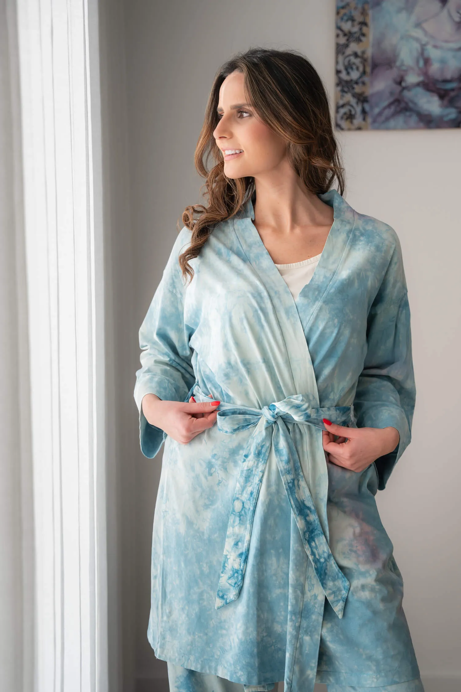 Modelo a usar o Robe Indicum em algodão orgânico com cinto, foto de estilo de vida em interior.